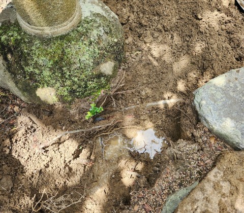 高松市内で漏水箇所を石の下で発見
